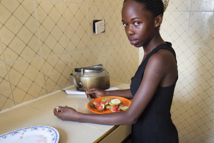 Agness Achan eats vegetables in her kitchen. She is among a growing number of Ugandan girls and women who struggle with eating disorders. (Photo by Edna Namara for GPJ Uganda)