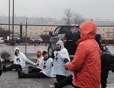 Activists chain themselves to block deportation vans in Tacoma on Monday. (Photo by Jill Mangaliman)