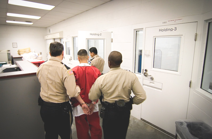 Guards book a new detainee into the Northwest Detention Center in Tacoma. The facility is run by the Geo Group, a private corrections corporation, on contract from the Department of Homeland Security