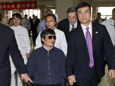 Chen Guangcheng, left, holds hands with U.S. Ambassador to China, Gary Locke, at a hospital in Beijing. Locke housed Chen at the U.S. Embassy in Beijing when he fled house arrest. (Photo from U.S. Embassy Beijing Press Office)
