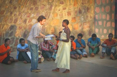 The author presenting an award to student Jocelyn following the performance of Making Peace in Old Village, August 2012. (Photo by Erika Rose)