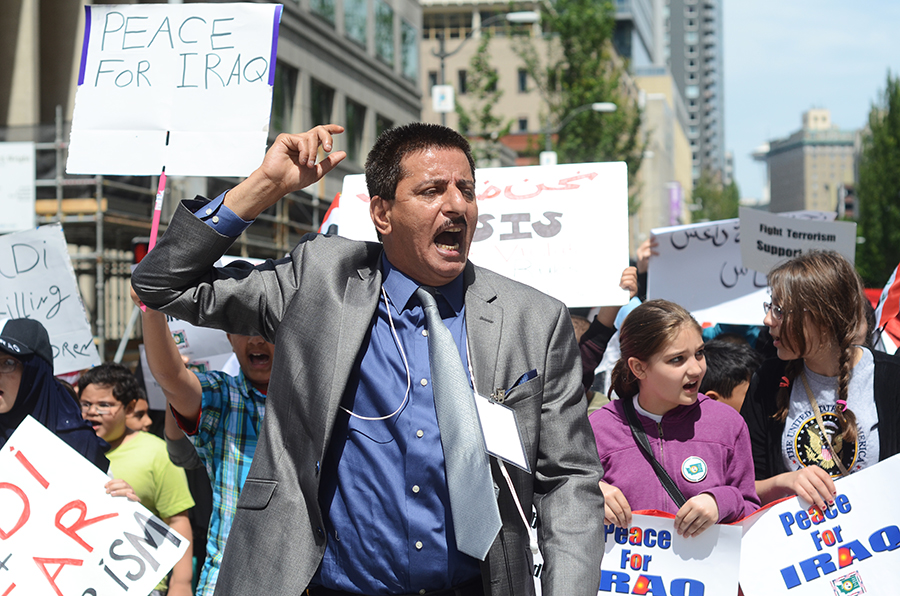 Walid Alkheyat, of the new Iraqi Community of Washington State leads a group of children, women and men to Seattle City Hall during a protest in June asking for US intervention in Iraq. (Photo by Alisa Reznick)