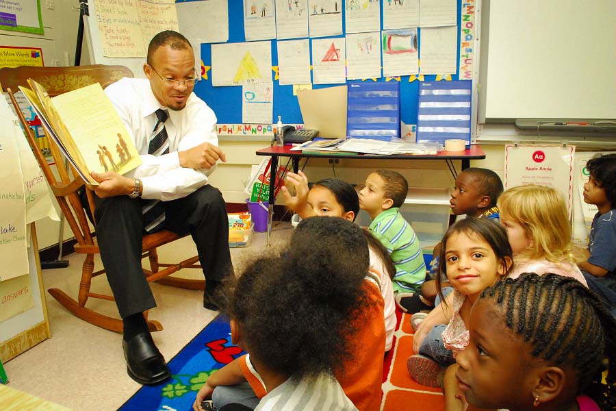 Harold Jones, a paralegal specialist and diversity officer at Navy Medicine Support Command, reads to first-grade students as part of a community volunteer program. (U.S. Navy photo by Mass Communication Specialist 1st Class Bruce Cummins)