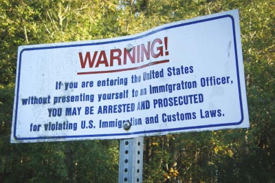 A sign on the U.S.-Canada border at Point Roberts warns undocumented immigrants against crossing illegally. (Photo by Makaristos)