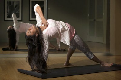 Yoga instructor Sweta Saraogi shows one of her moves in the yoga studio she teaches out of in her condo in Seattle. (Photo by Ellen M. Banner / The Seattle Times)