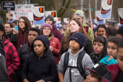 Seattle kids listen to Heirius Howell talk about his experiences in the King County youth jail at an MLK day rally earlier this year. (Photo by Alex Garland)