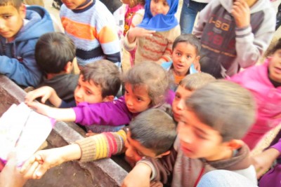 Children in a camp for Syrian refugees clamor for aid distributed by SACCWA. (Courtesy photo)