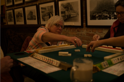 Doreen Zemble, a member of Mah Jongg Fever is picking the tile during the game. (Photo from the Seattle Globalist by Yiqin Weng)
