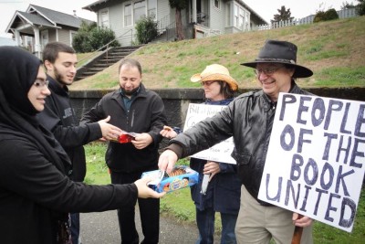 Zainab Haji (left) gives cookies to Kent Chadwick, who turned out in support of the Islamic Center of Kitsap County in 2015 in response to announced plans for an anti-Islam rally the Bremerton mosque. No protestors actually showed up. (Photo courtesy CAIR-WA)