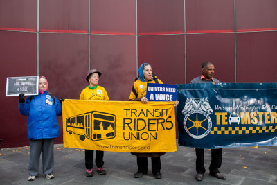 Members of the Transit Riders Union and Teamsters Local 117 stand in support during the Voice for Drivers rally today at Seattle City Hall. (Photo by Jovelle Tamayo)