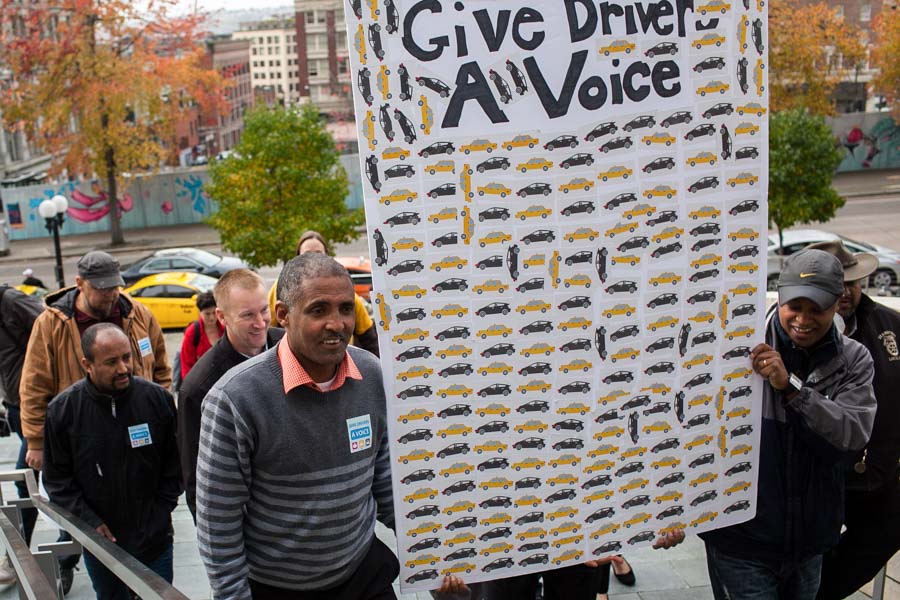 Taxi drivers Getachew Mersha (left) and Dawit Tesfaye lead a group of drivers and community members on their way to deliver a petition to Mayor Ed Murray's Office requesting rideshare drivers be allowed to unionize. (Photo by Jovelle Tamayo)