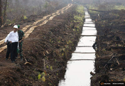 Indonesian President Joko Widodo inspects a newly-built canal to prevent underground spreading of peatland fires. Fires are out for now, but government officials warn they could be back as soon as February. (Photo by REUTERS/Darren Whiteside)