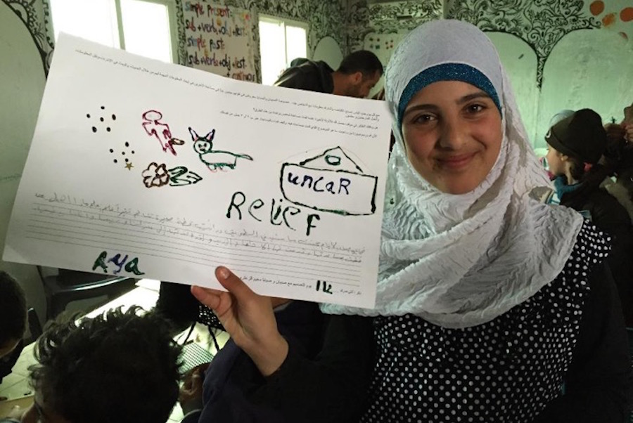 A Syrian girl holds up a poster she drew “about how she recently helped someone using information or technology” during UW professor Karen Fisher’s workshop at Za’atari refugee camp in Jordan in January 2015. (Photo courtesy of Karen Fisher, University of Washington Information School)