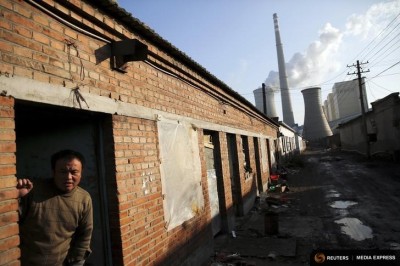 A migrant worker steps out of his home next to a coal power plant in Beijing. (Photo from REUTERS / Damir Sagolj)