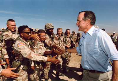 President George H. W. Bush visits American troops stationed in Saudi Arabia in 1990, in the lead up to the first Gulf War. (Photo from the Bush Library via Wikipedia)