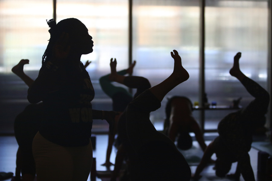 Irene Auma, at center, helps conduct a yoga class at Thursdayin Seattle. Auma plans to start the first yoga-in-prisons program in Kenya. (Photo by Ken Lambert / The Seattle Times)