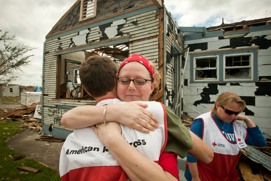 Tonya Miller hugs a Red Cross volunteer in front of her home in Joplin, Missouri following the 2011 tornado. (Photo from Flickr by Ozarks Red Cross)