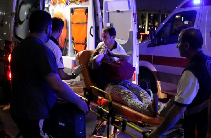 An Injured Woman Covers Her Face As She Is Carried By Paramedics Into ...