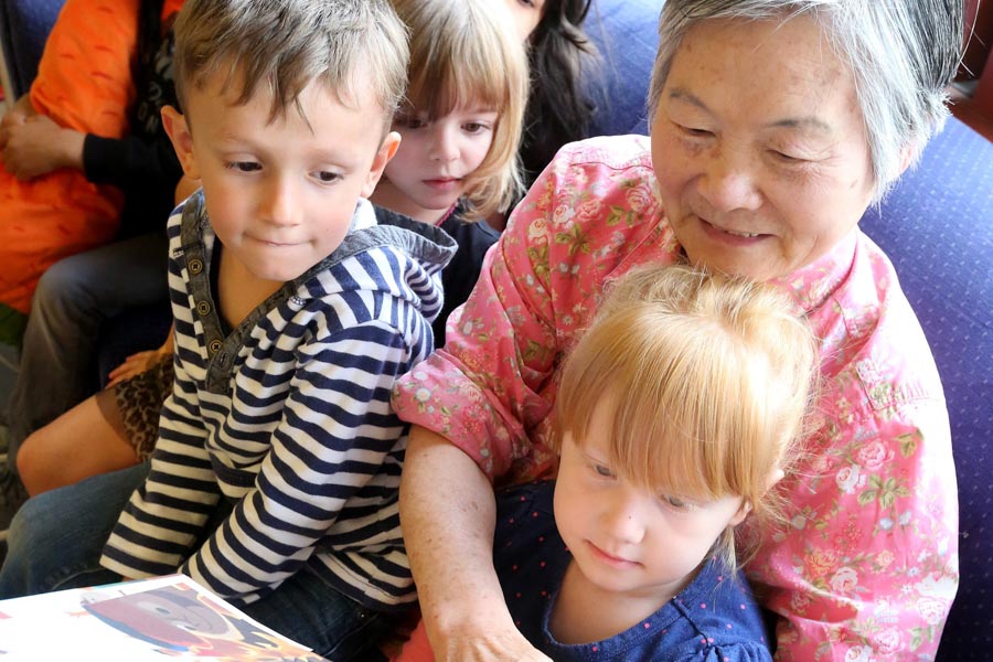 Fen Fang Jiang, 72, reads to kids at Pike Market Childcare in the Pike Place Market. Jiang is part of the "Foster Grandparent" program. (Photo by Greg Gilbert / The Seattle Times)