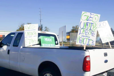Employee cars and trucks parked outside of the Northwest Detention Center yesterday had picket signs charging "unfair labor practices" and understaffing" at the privately-run facility. (Photo by Victoria Mena)