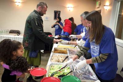 Volunteers serve food at last year's interfaith Christmas Eve Dinner. (Photo courtesy Muslim Community Resource Center)