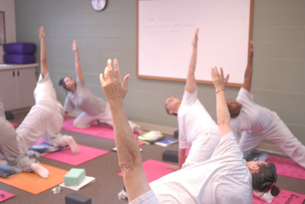 Inmates of the Washington Corrections Center for Women practice yoga at a Yoga Behind Bars teacher training. (Photo by Emily Westlake)