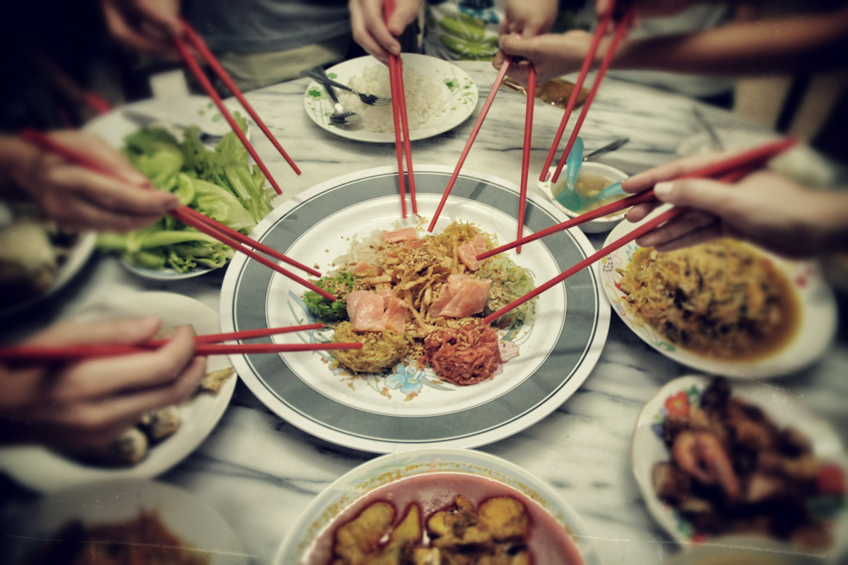 Getting ready to toss yee sang aka yu sheng. (Photo from Flickr by C.K. Koay)