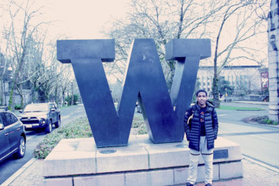 Tibebu Proctor stands in front of the giant "W" at the North end of the University of Washington campus. When choosing which college where he would run, he chose Washington over Wake Forest, because of Washington's proximity to home. (Photo by Andy Yamashita)
